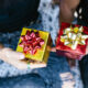 Two persons sitting together with gift boxes on their hands.